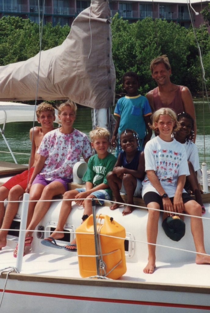 family of eight on bow of sailboat