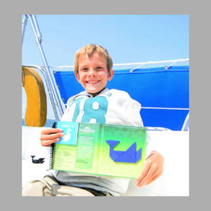 child playing with travel magnetic tangoes book in the cockpit while sailing 
