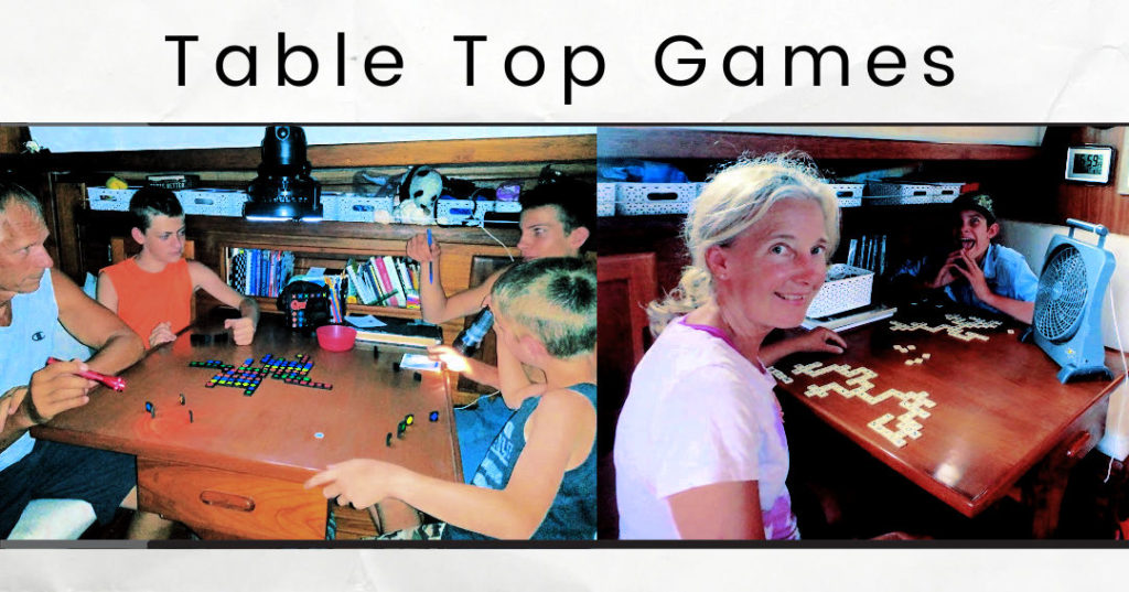 grandparents and grandchildren playing travel Qwirkle and Bananagrams in cabin of our boat