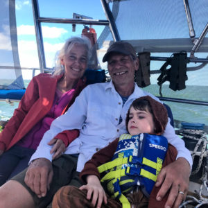 grandparents with grandson in cockpit of sailboat