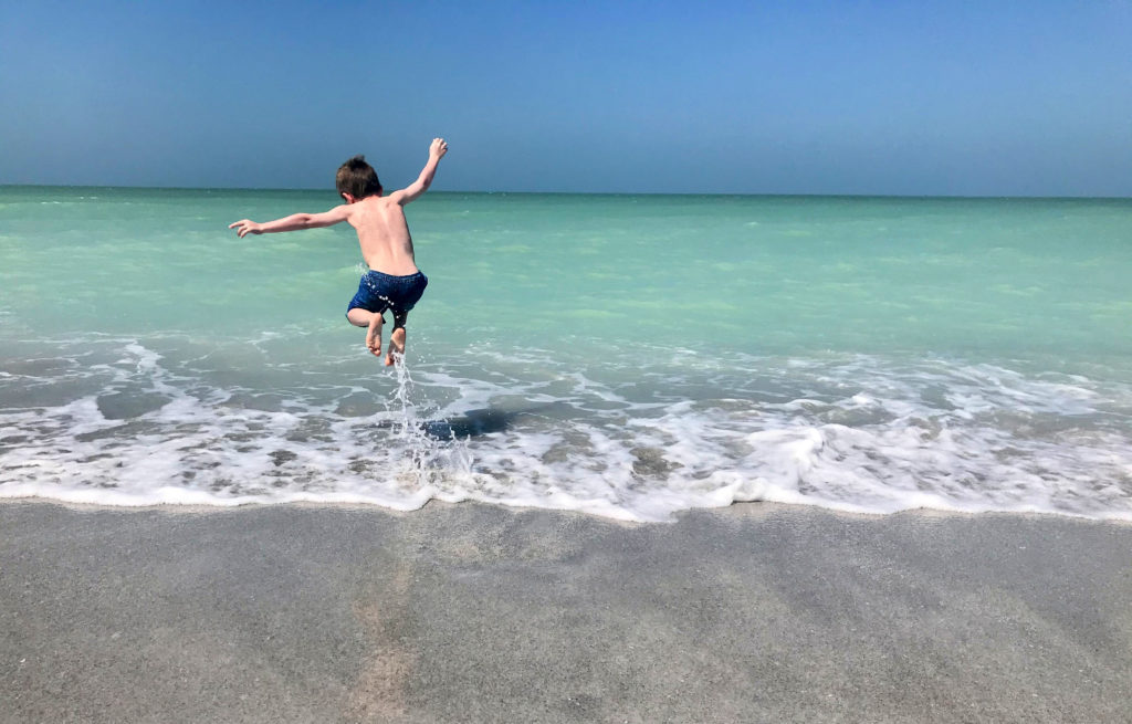 Titus jumping the waves at the beach