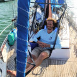 adult son in hanging chair on sailboat 
