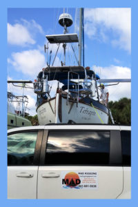 van parked in front of sailboat on hard, van advertising MAD rigging
