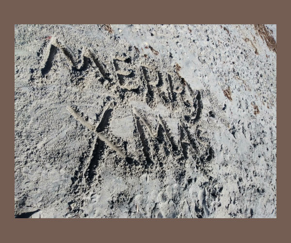 Merry Christmas written in sand at beach
