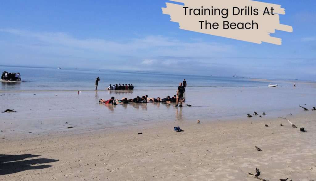 groups of young students performing marine training drills at the beach
