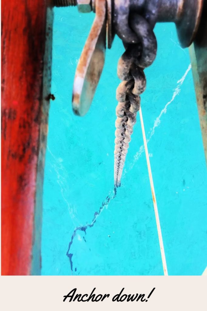 anchor chain going down off the bow into the clear waters of the Exumas
