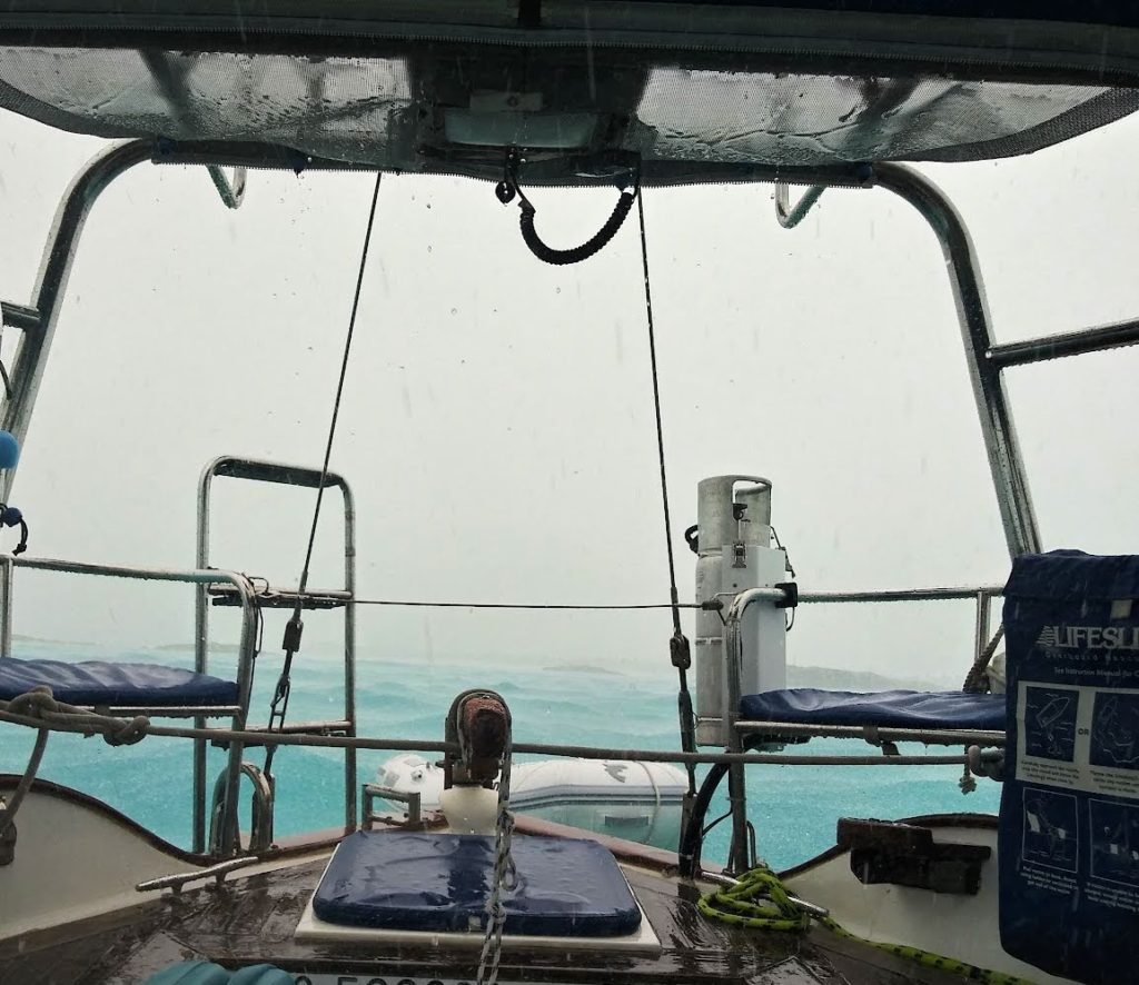 view from cockpit of sailboat of a heavy downpour while at Shroud Cay 