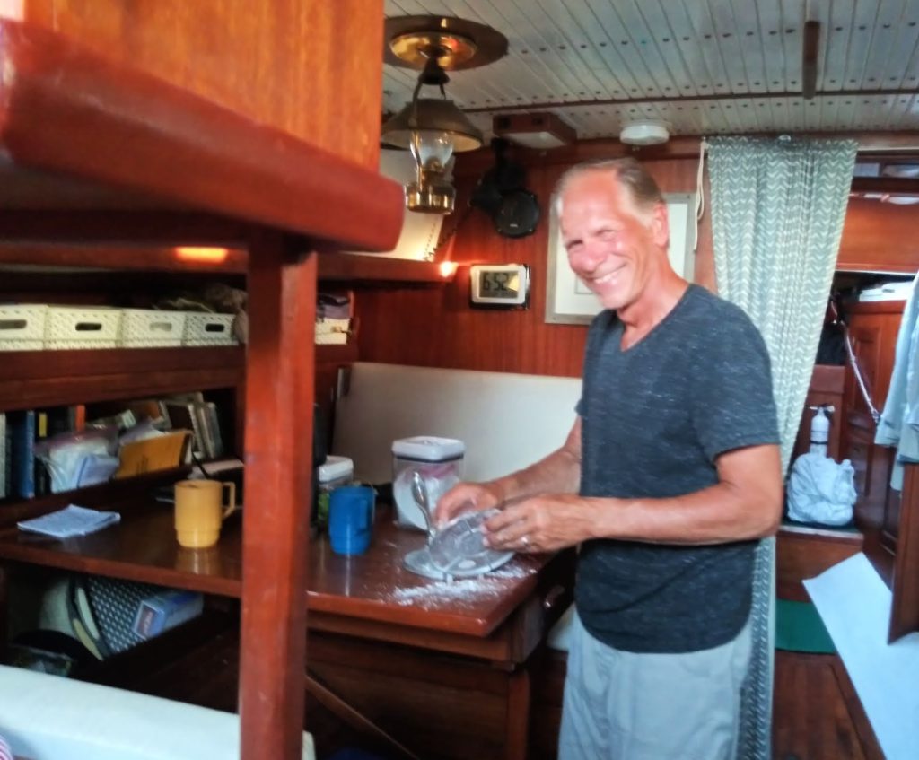 Tony helping make tortillas in cabin of our sailboat 