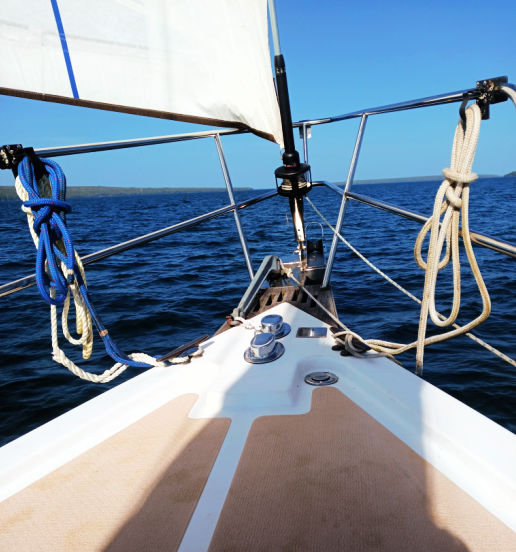 bow of sailboat with sail out on Lake Superior 