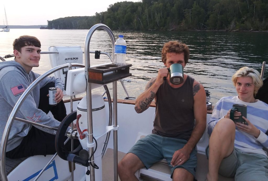 group in the cockpit drinking coffee while at anchor near wooded island 