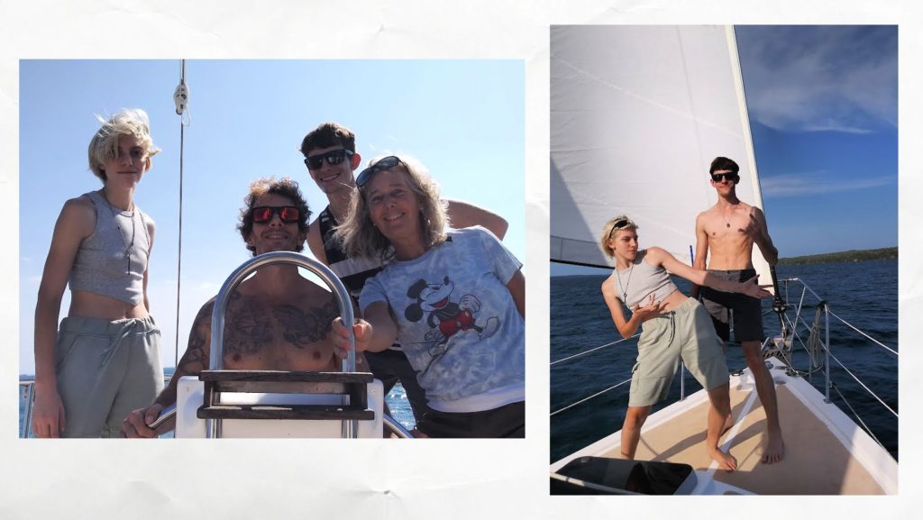 group of family around wheel of sailboat, your adults on the bow while sailing
