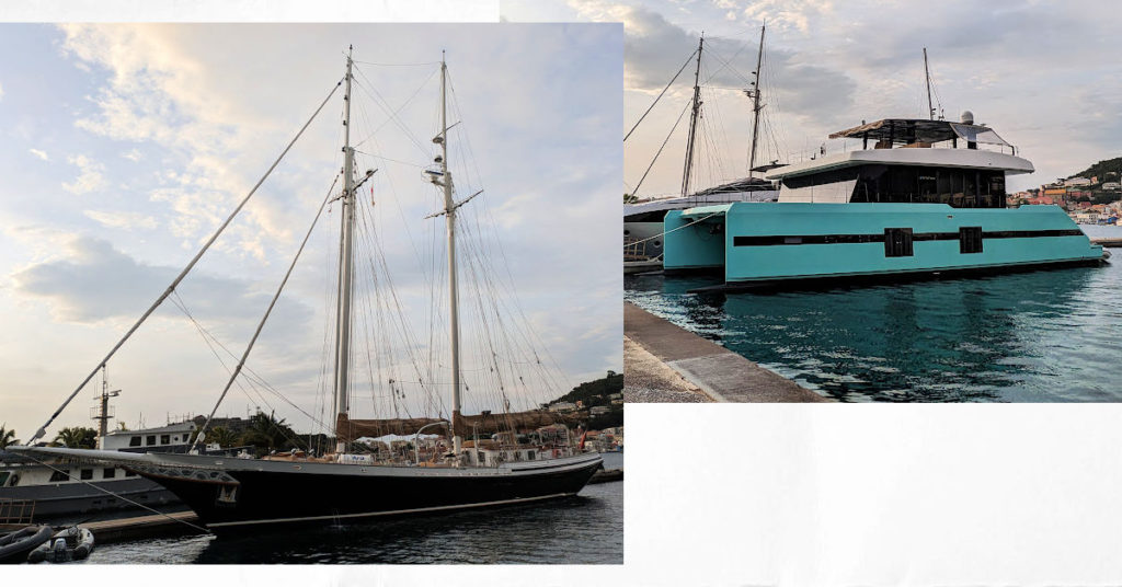 two large boats, one monohull sailboat and one catamaran at dock