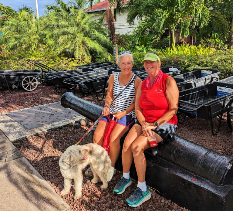 two ladies sitting with dog in marina entrance area 