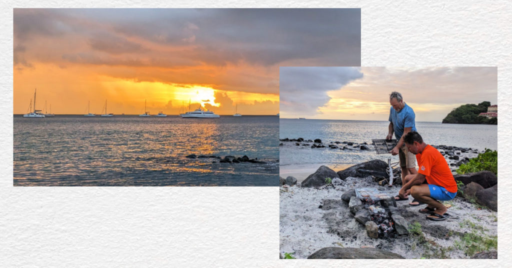 men preparing to cook food at beach barbeque, sunset over the water with sailboats anchored 