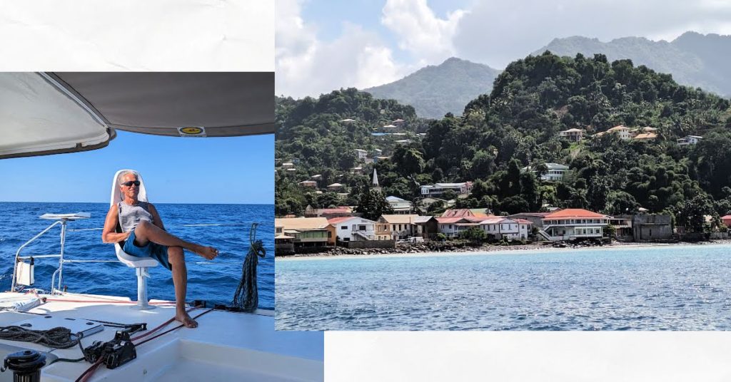 landscape of Grenada hills and houses from the water, man on a sailboat with blue water and blue sky 