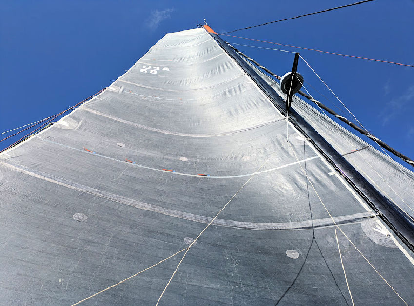 sails up on an Outremer 51 sailboat, blue sky in background 