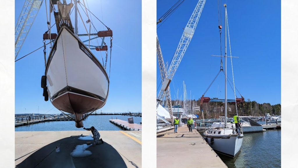 sailboat in sling with man doing touch up paint to bottom of hull, boat getting launched into the water 