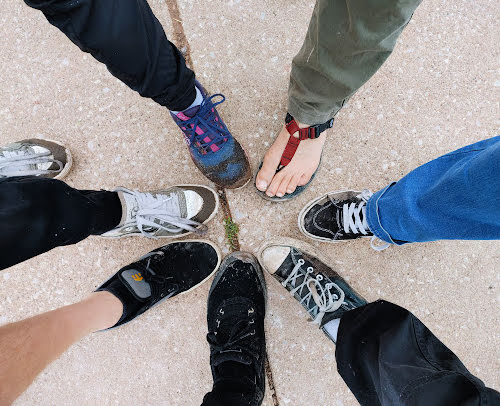 six  shoes in a circle after hike on a muddy trail