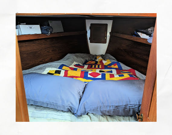 Vberth on sailboat with pillows and a colorful quilt 