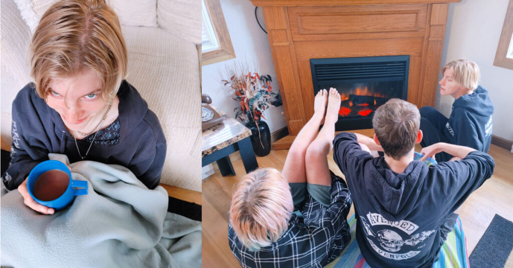 3 young adults in front of fireplace warming up, person drinking hot chocolate 