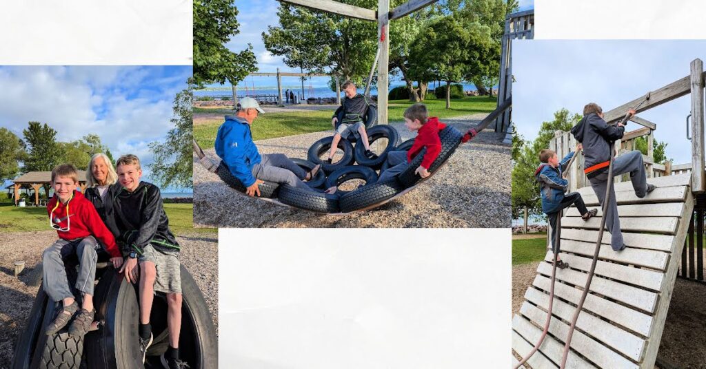 grandparents and boys enjoying a local playground, climbing wall, tire swing, tire structure 