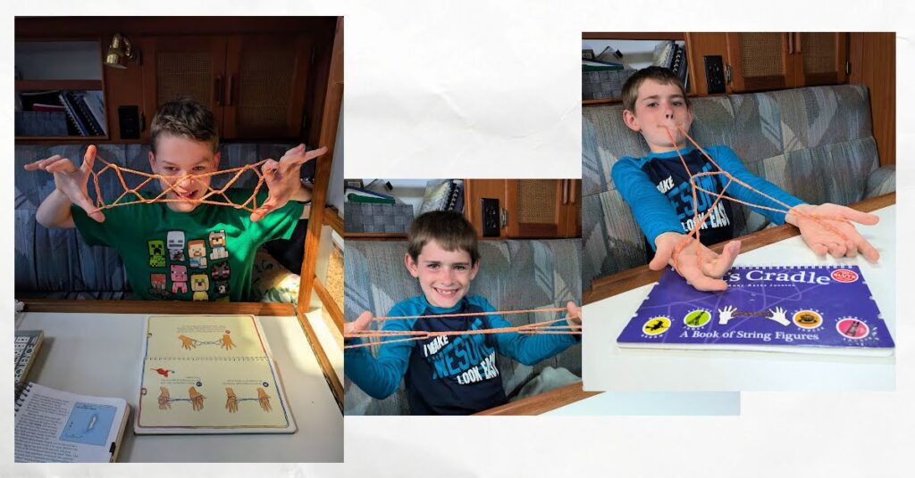 boys doing cats cradle string games in the cabin of a boat 