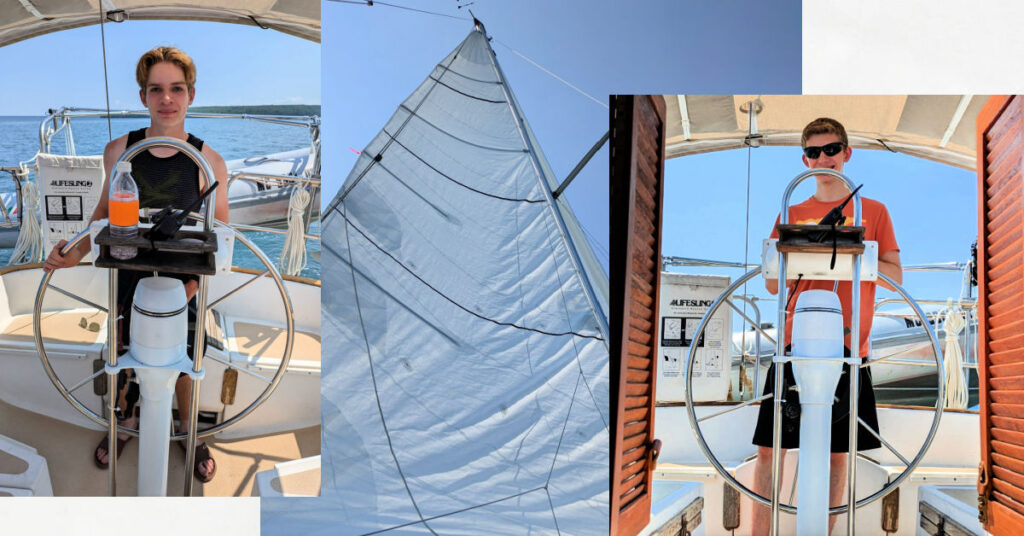 teen grandsons at the helm of sailboat, white main sail with blue sky 
