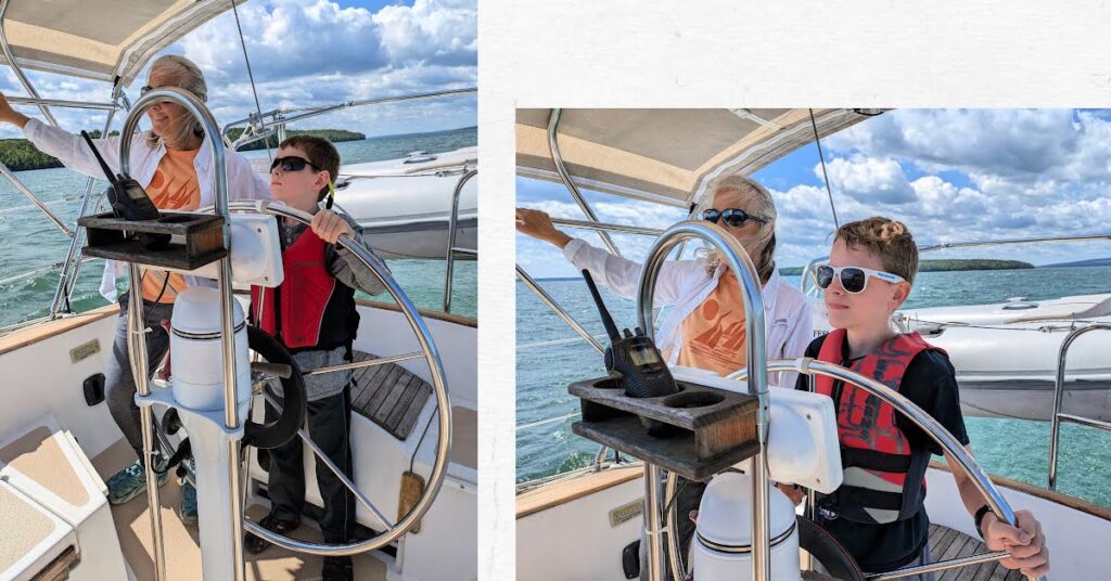 boys at the wheel of sailboat with grandma standing next to them