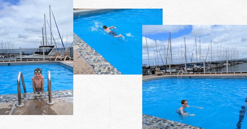 boys swimming in the marina pool with sailboats in the background