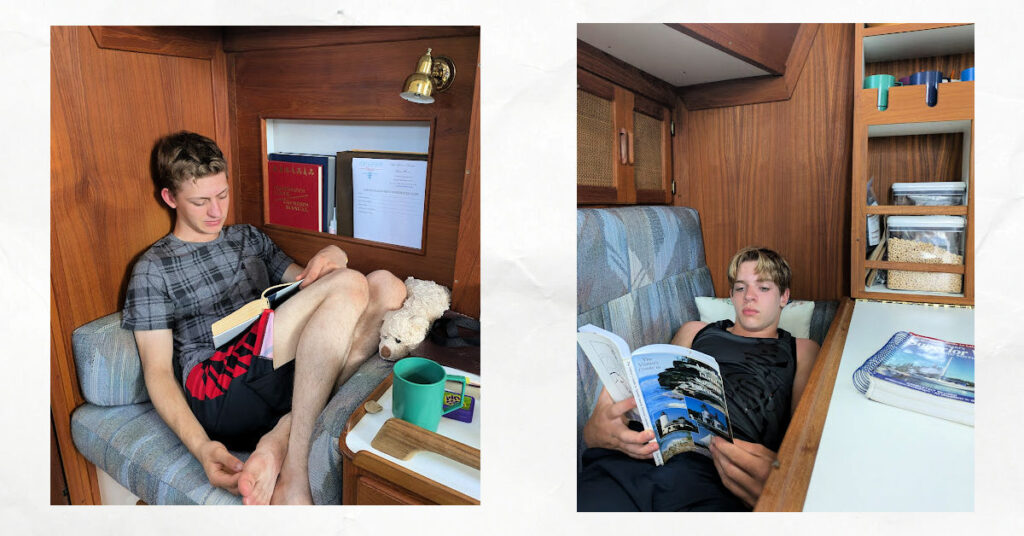 teen boys reading books in sailboat cabin 