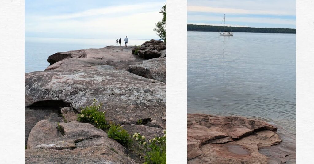 large boulders with grandpa and grandsons walking on rocks, sailboat in the anchorage from view of large rocks on shore