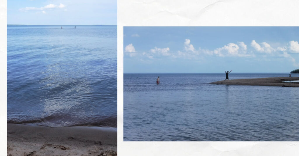 teen boys walking out on shallow sandbars to reach a sandspit on lake superior