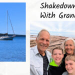 sailboat at anchor, grandparents and grandsons on big rocks overlooking water