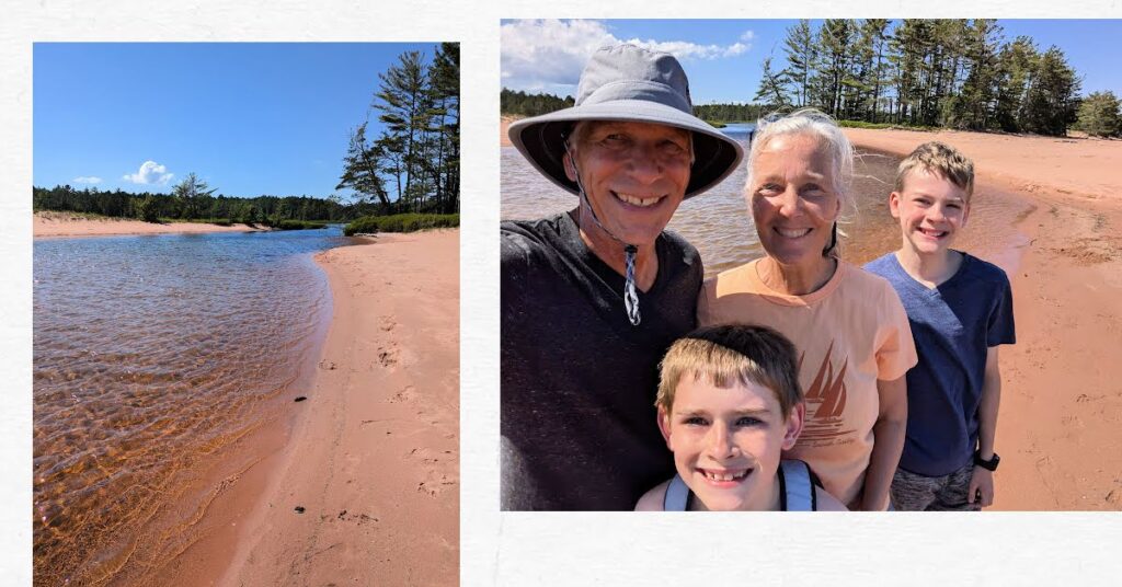 stream with beach on either side, grandparents and grandsons on edge of stream 