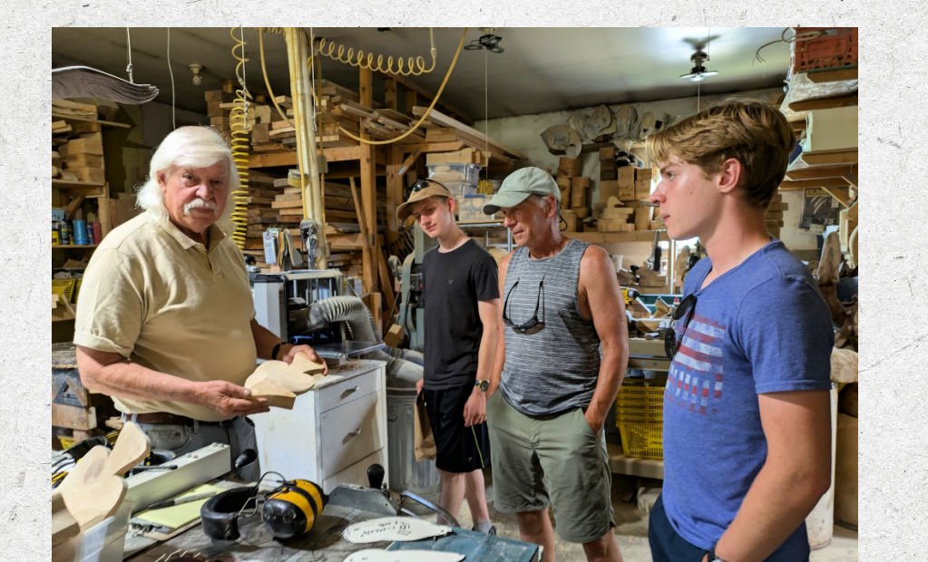 men inside a woodworkers shop looking at projects 