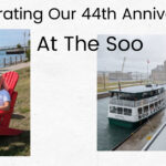 man looking at boat going through locks, woman on red chair by river at the soo