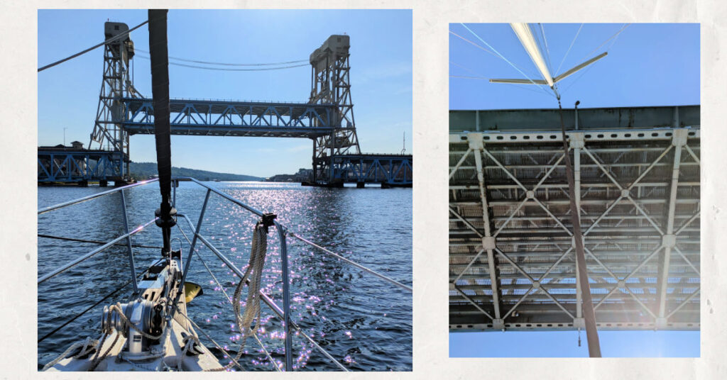 houghton hancock lift bridge with sailboat approaching and sailboat mast going under bridge 