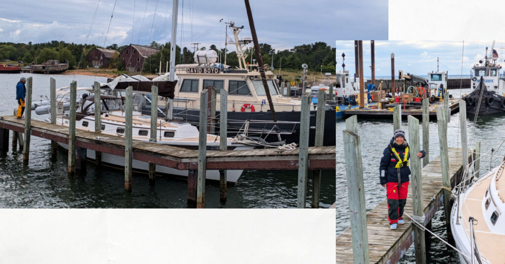 dock at Whitefish Point with fishing boats and dredging equipment, woman in full foul weather gear and winter hat 