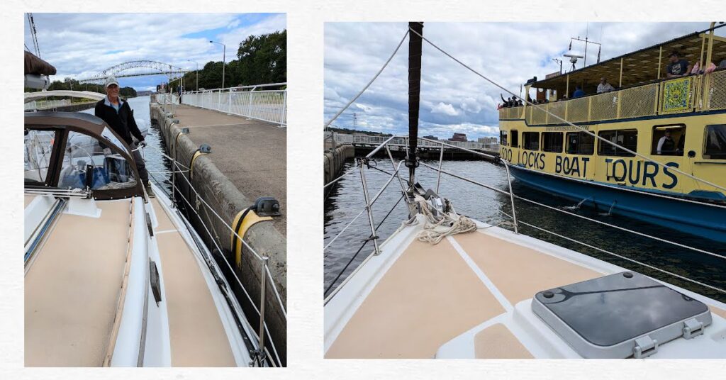 man on sailboat ready for the water to drop in the locks, tour boat on the other side of the locks from sailboat 