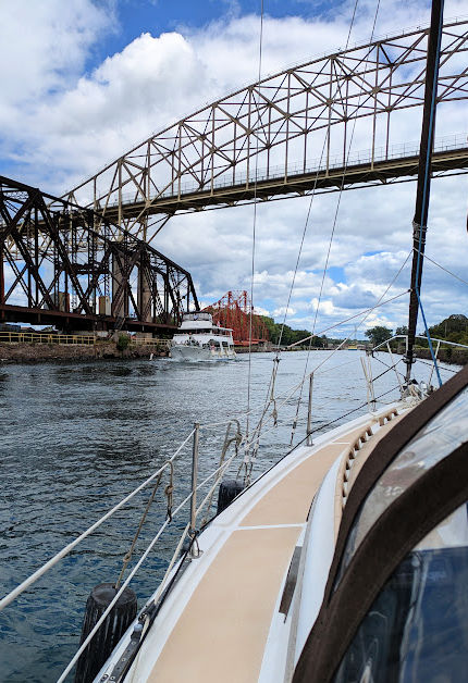 going under lift bridge in sailboat with power boat approaching the other way 