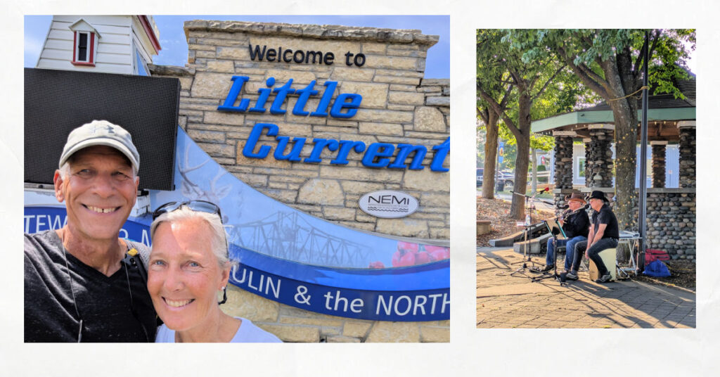 couple in front of city sign for Little Current, band playing an outdoor concert in the park