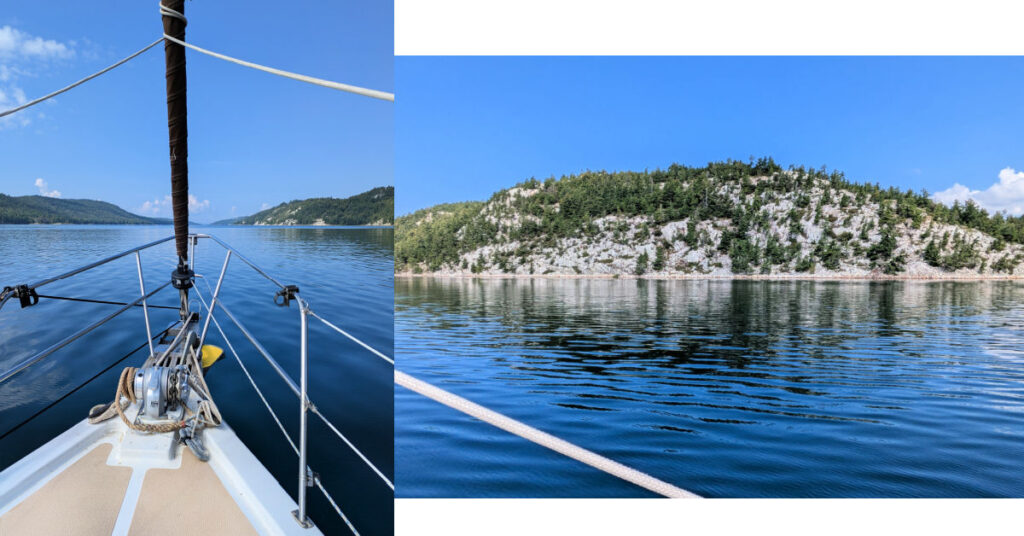 sailboat entering Baie Fine, white quartz mountains along water