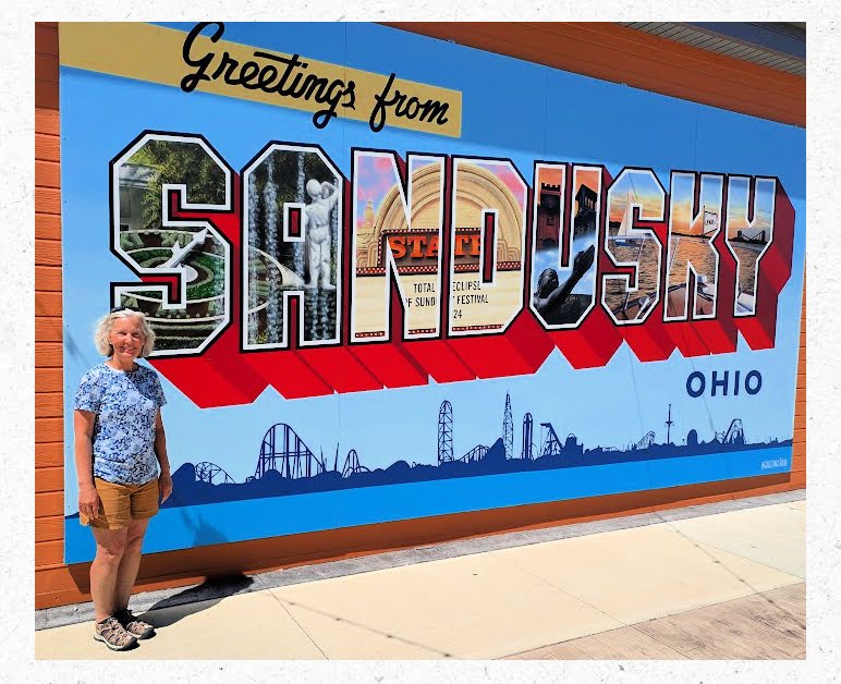 women in front of sandusky city welcome sign 