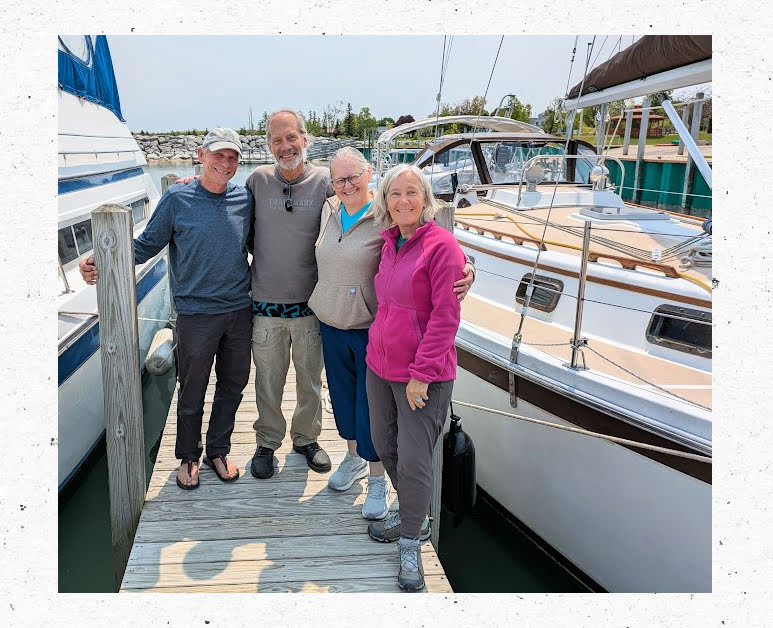 4 siblings on teh dock next to sailboat 