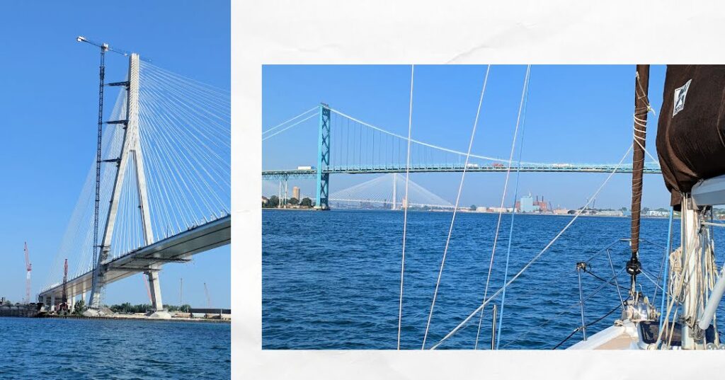 bridges as seen from sailboat, one section of tall bridge under construction with crane 