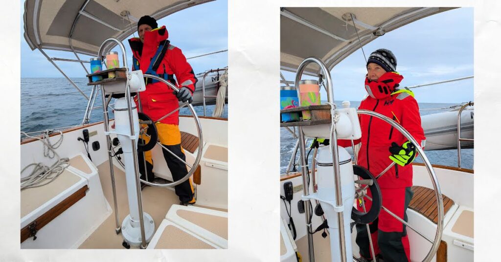 sailors in foul weather gear, winter hats, gloves at helm of sailboat on cold day on the water 