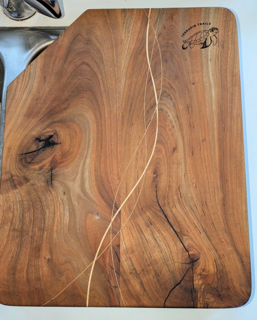 close up of a custom cutting board with turtle woodburning into it.  