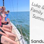 family on cabin top of sailboat while sailing on Lake Erie