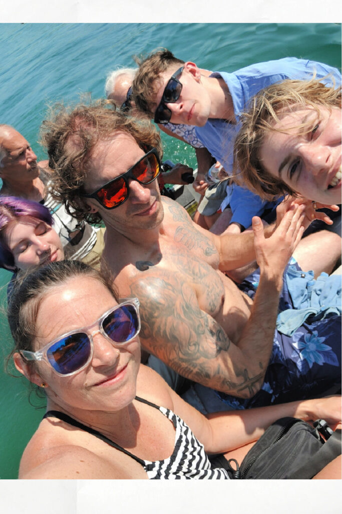 seven adults in a small inflatable dinghy on a calm day 