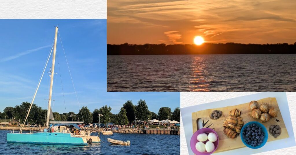 sunset over water, catamaran in anchorage with concert tents on shore, charcuterie board with bakery, fruit, eggs, almonds 
